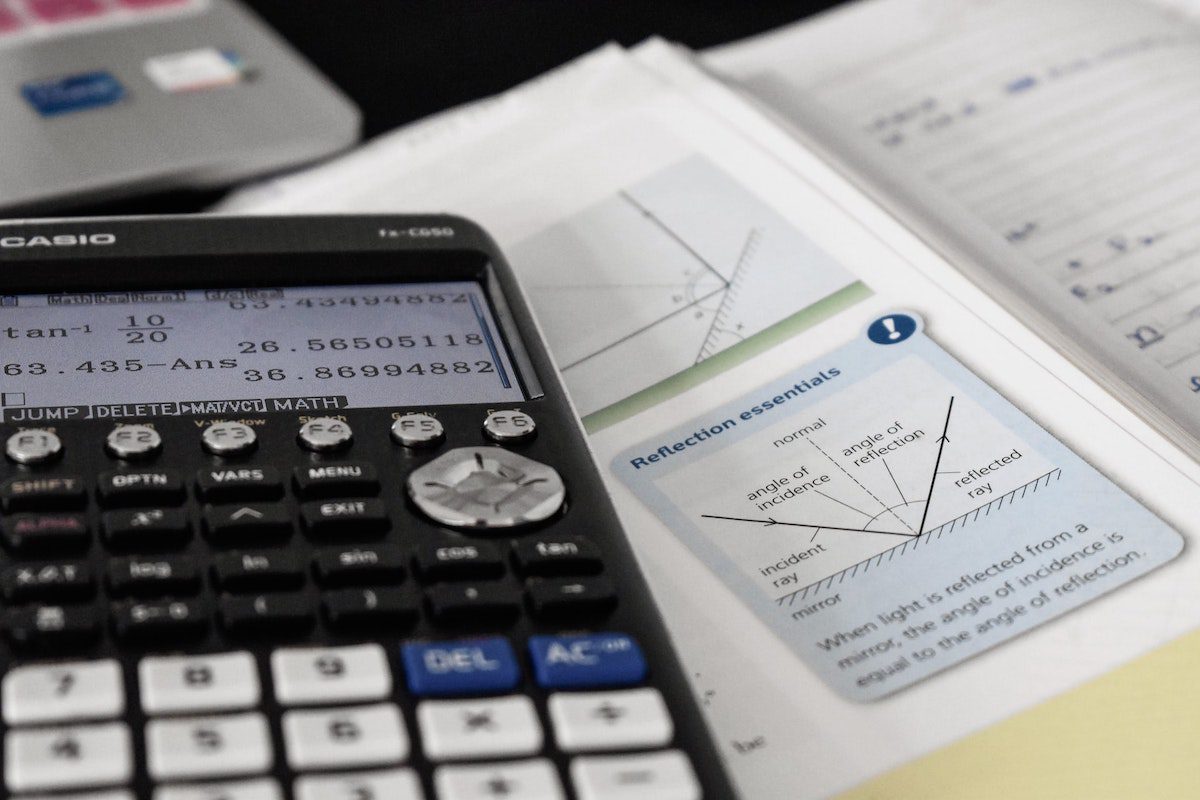 A calculator and mathematics books on a table.