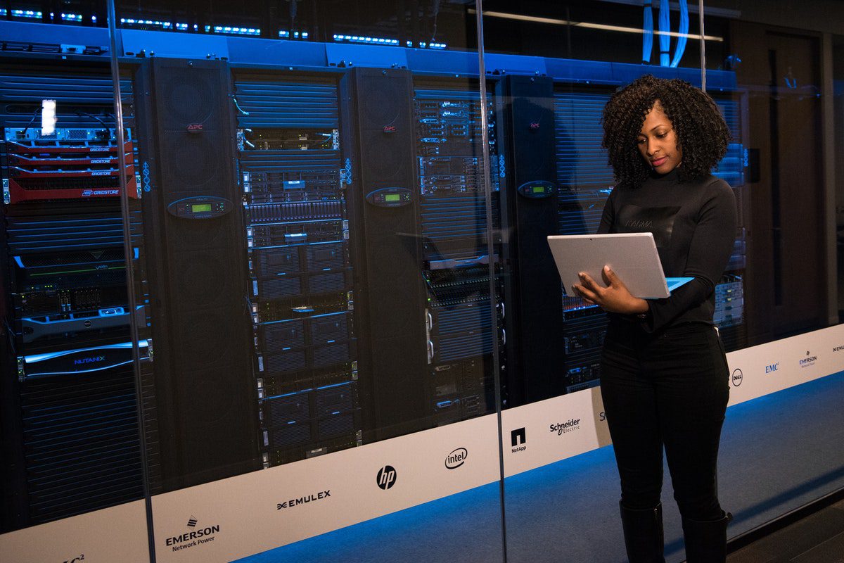 A database developer standing beside server racks