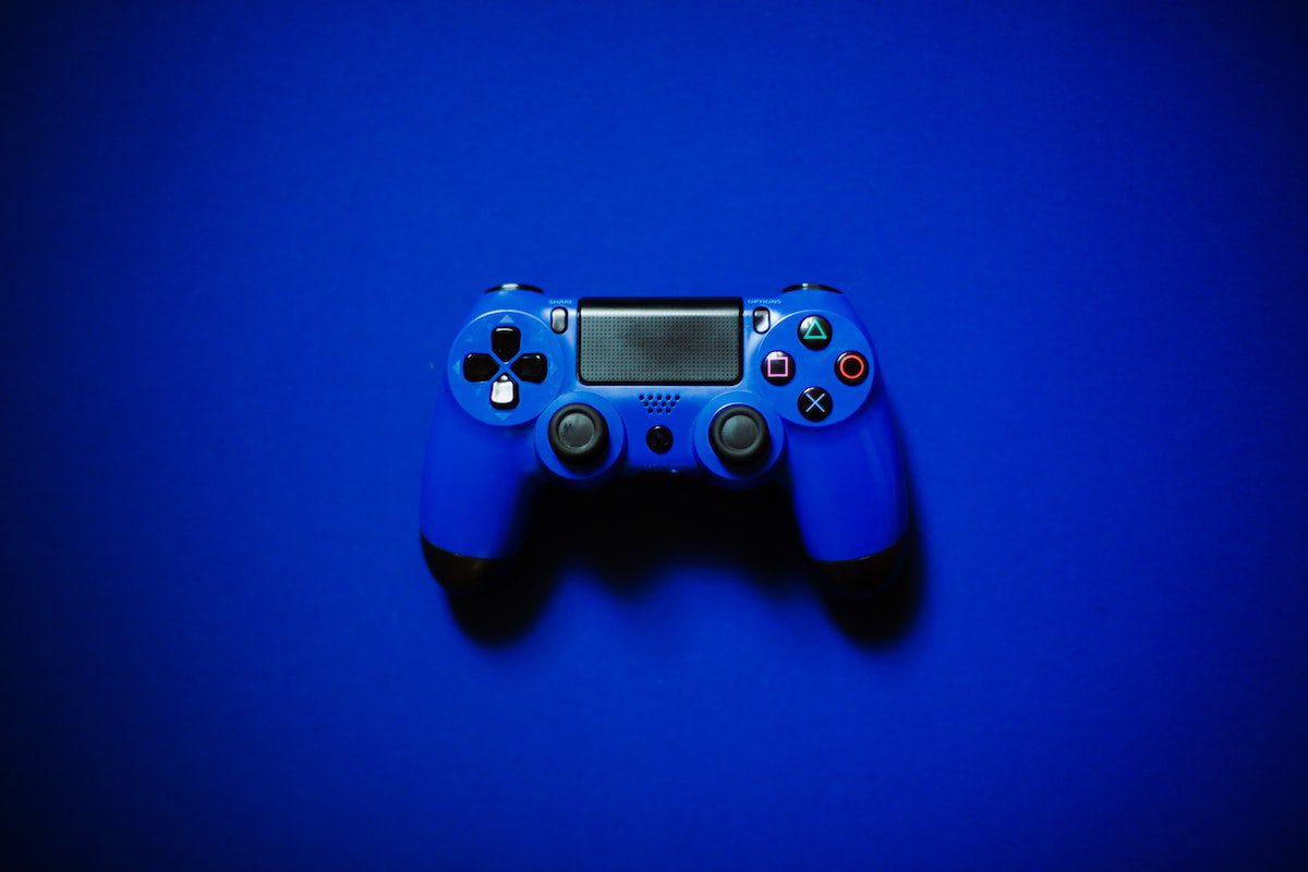 A blue Playstation controller set against a blue background.