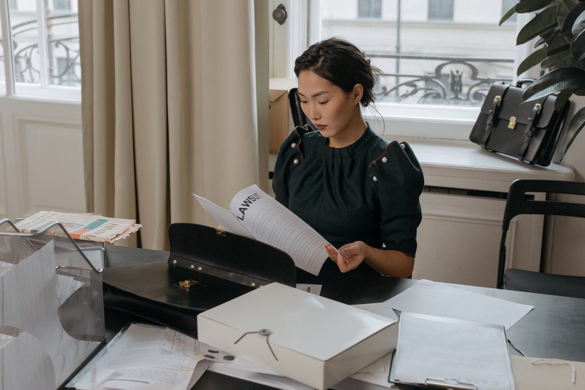 A female lawyer reading a lawsuit document 