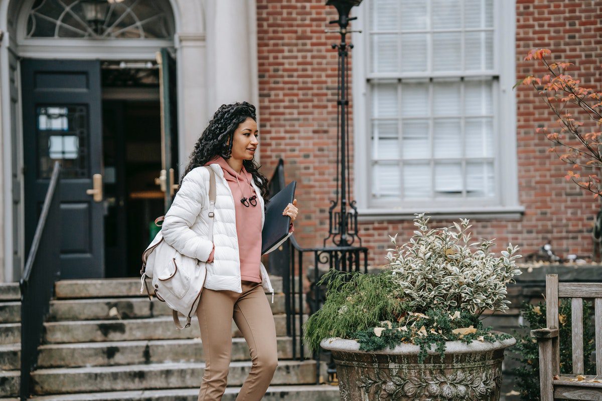 A female college student walking in front of a technical community college building