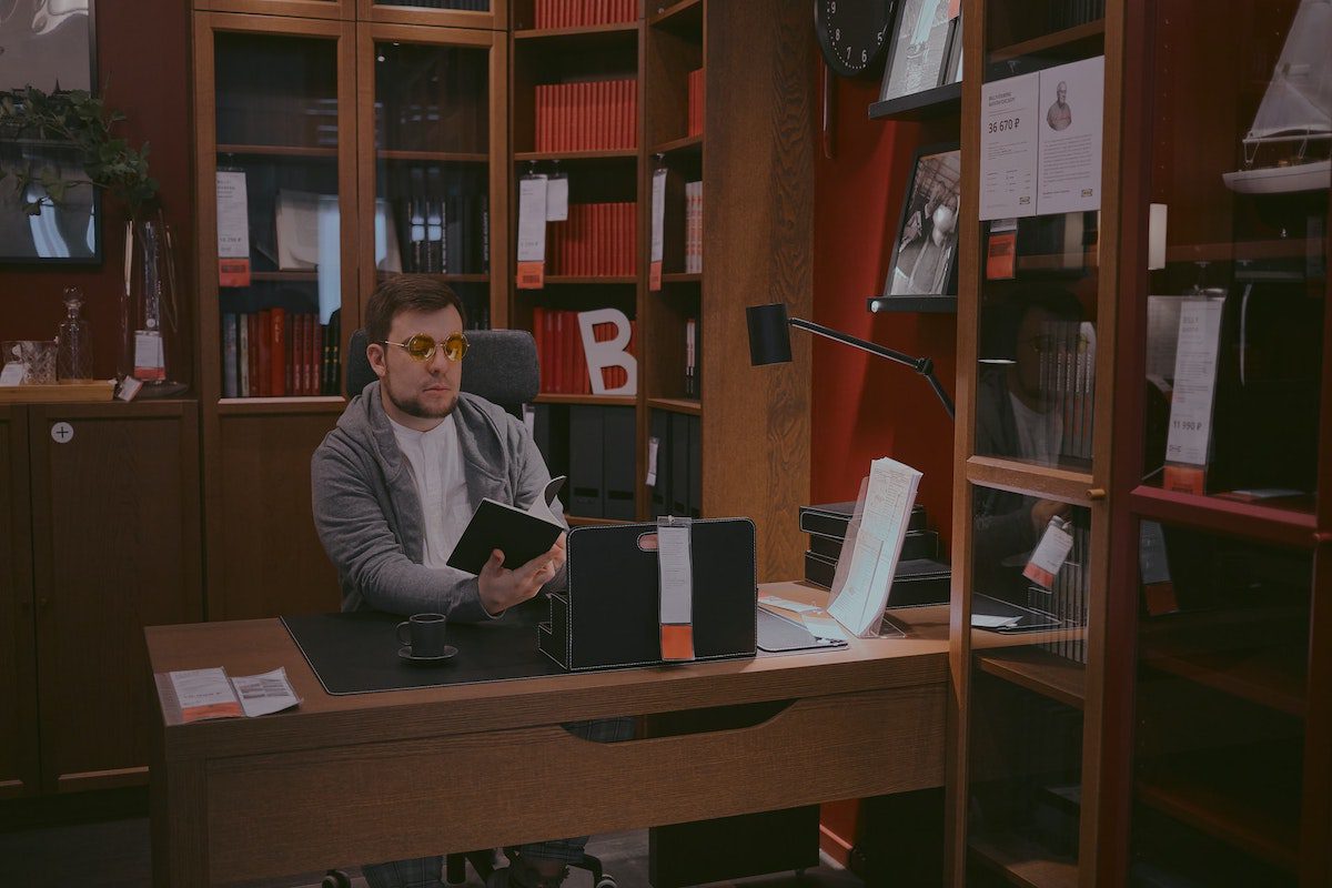 A doctoral student reading a book in a library