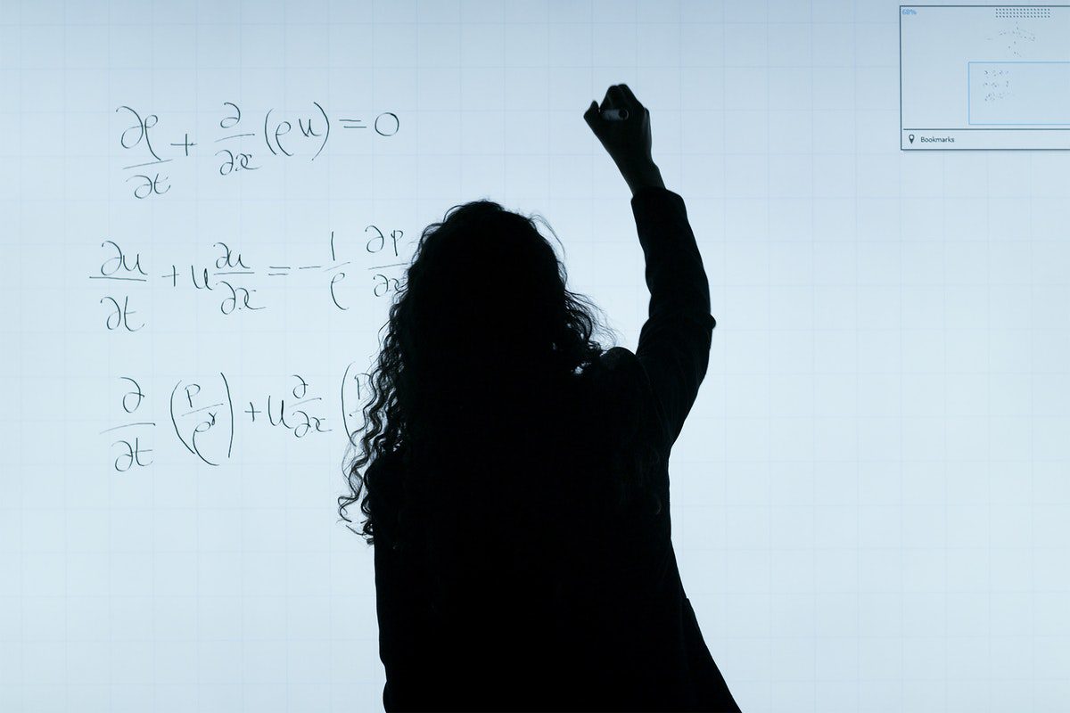 A woman writing on a whiteboard