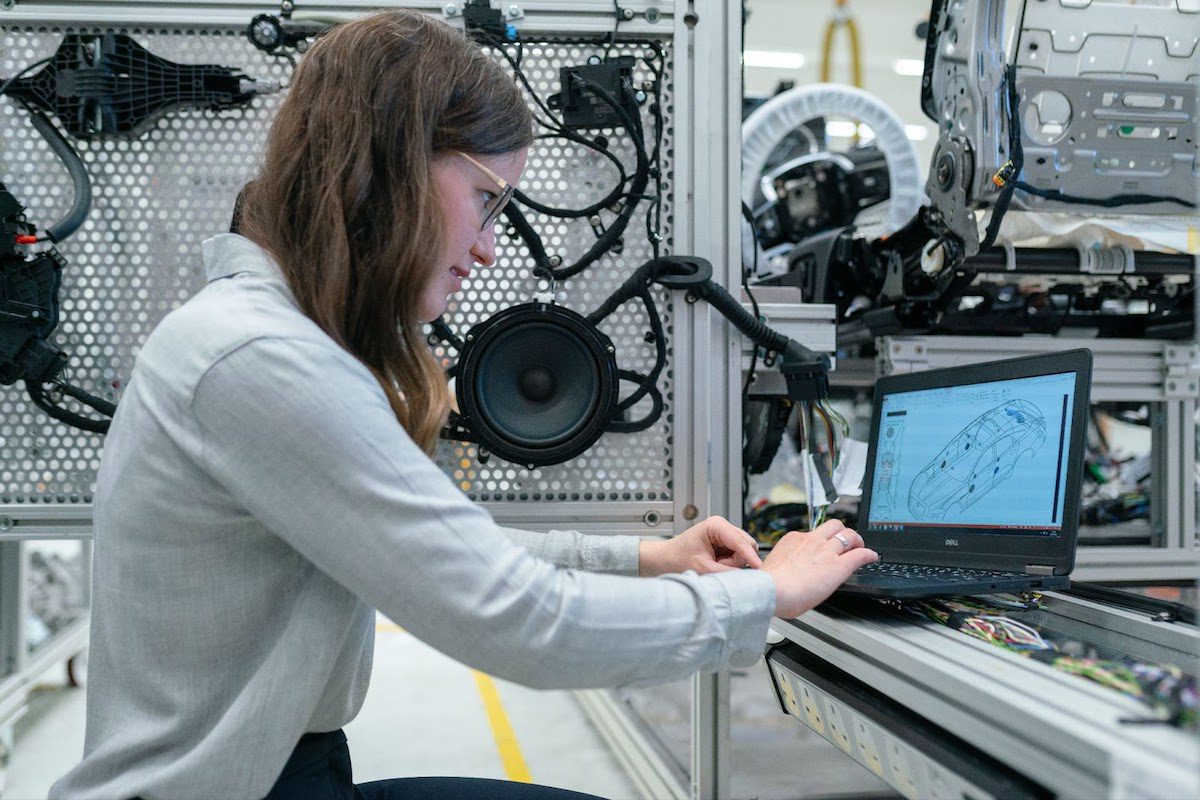 A female electronics engineer conducting vehicle tests on a computer