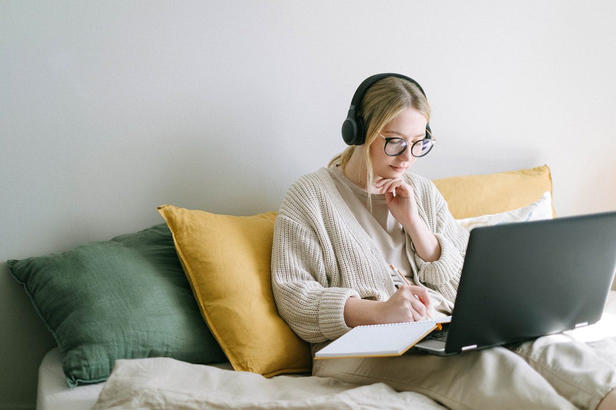 A female tech beginner looking at a laptop screen while taking an online intro to information technology course