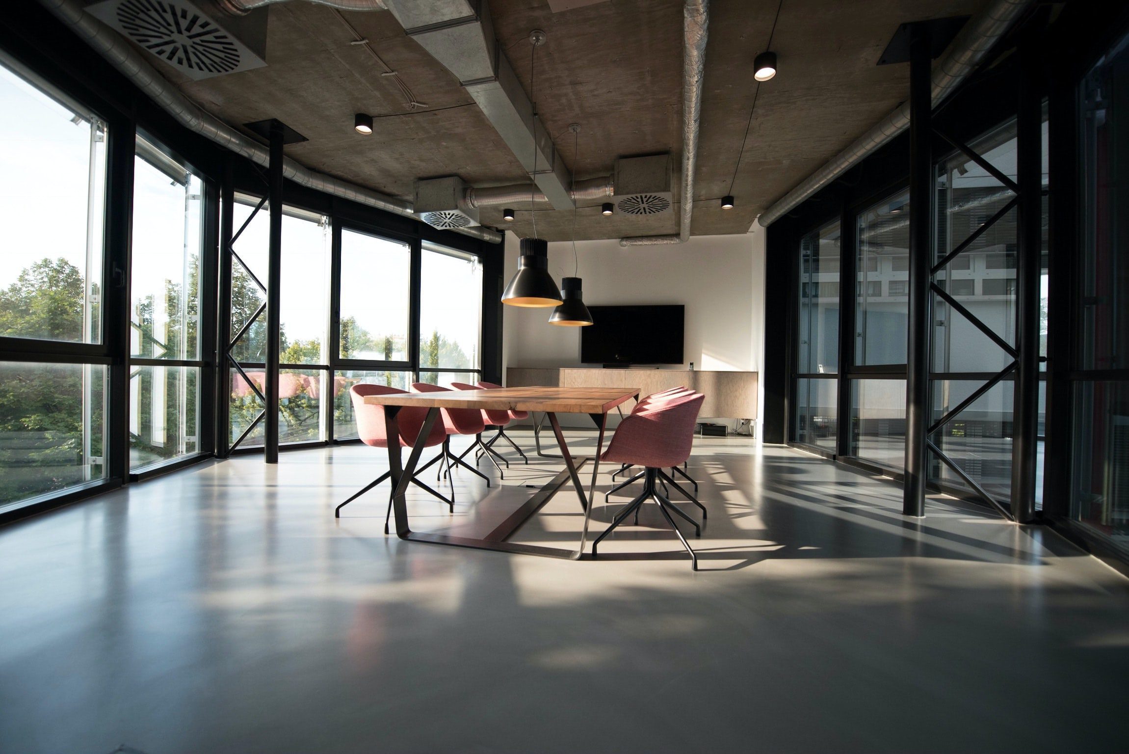 Spacious conference room with eight chairs and large windows.