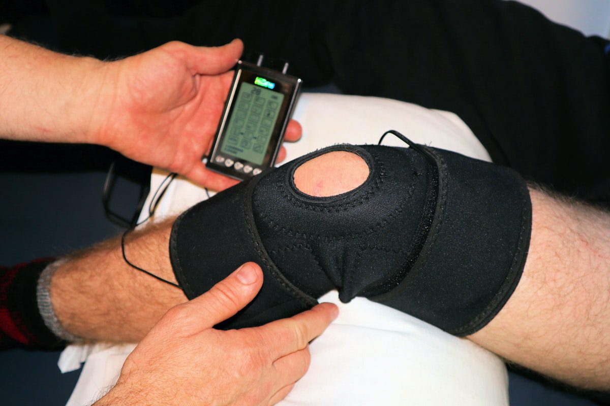 A sports medicine professional administering a treatment plan with physical therapy equipment.