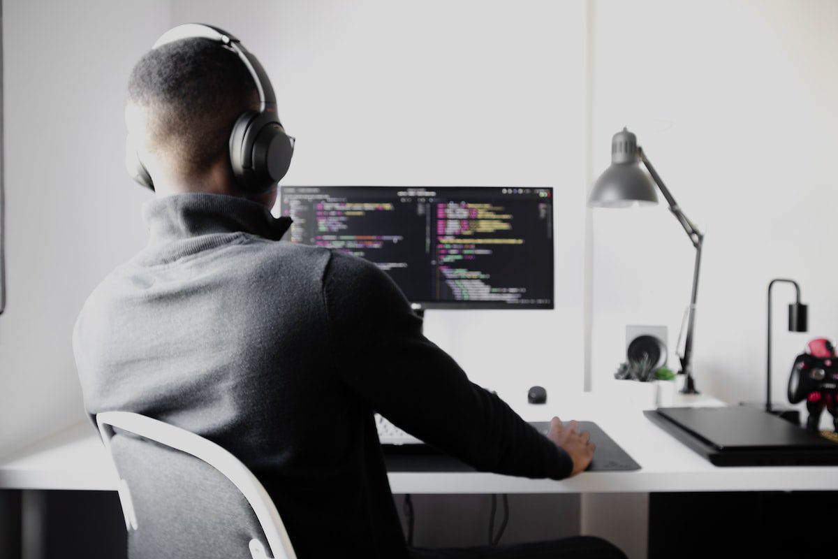 A software programmer types codes into a program on a desktop computer.