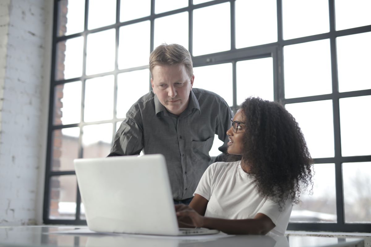 Two people in front of a laptop considering something on the screen.