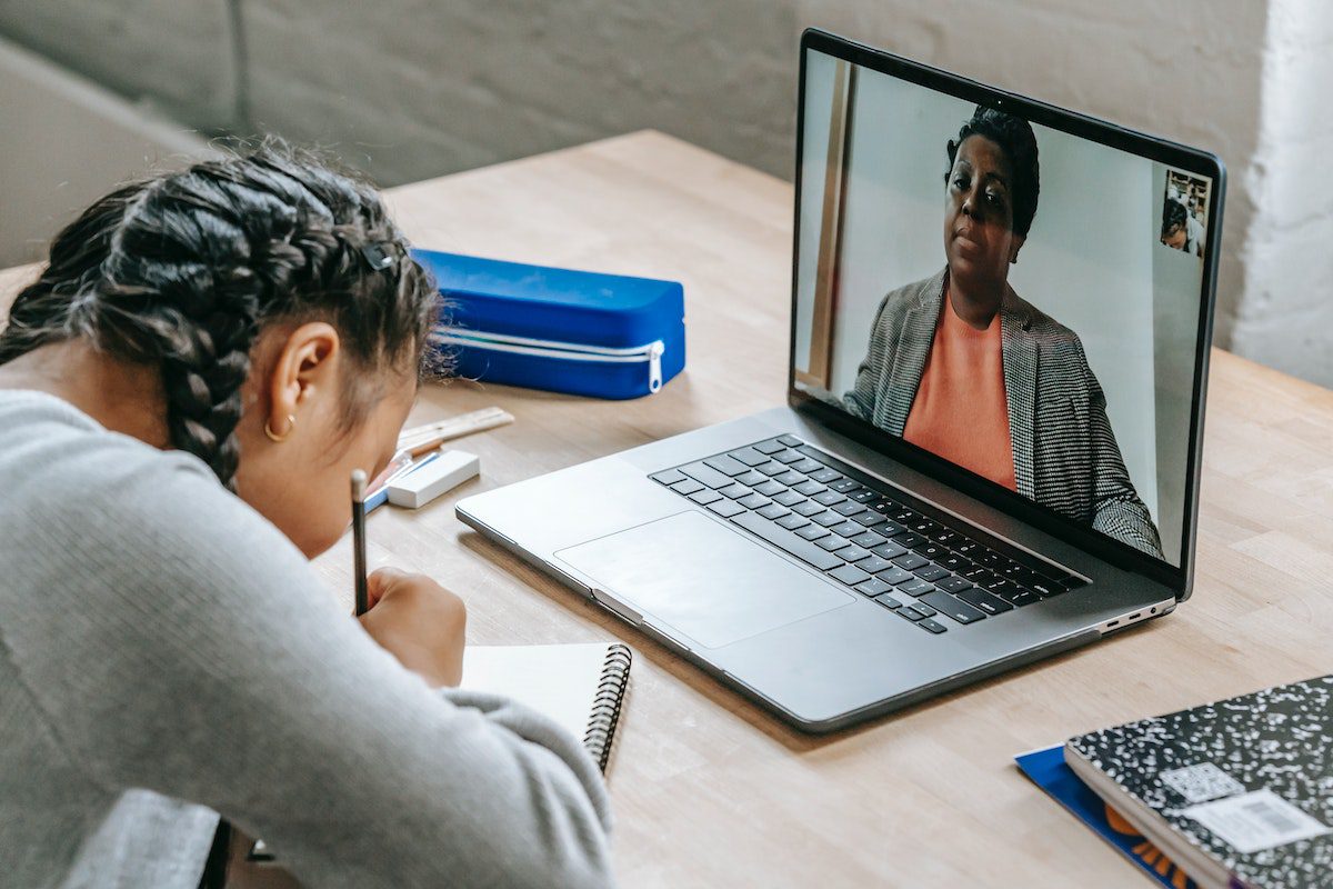 Woman watching an online lecture and taking notes