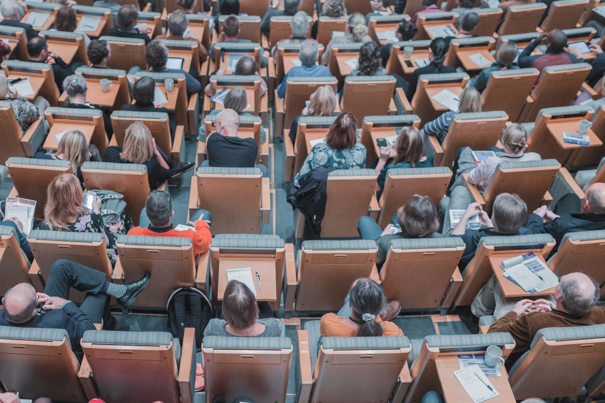 Students sitting in a lecture room looking at the professor.