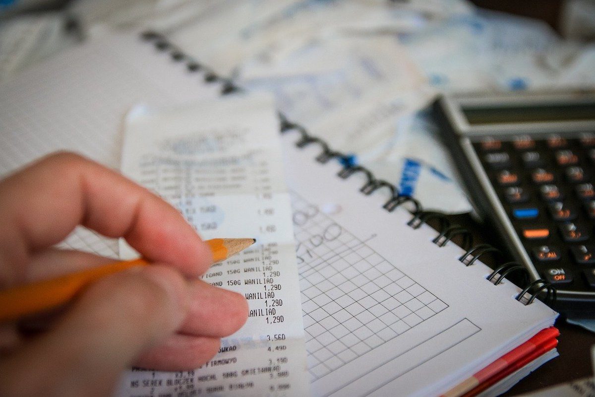 A person working with a calculator and some receipts