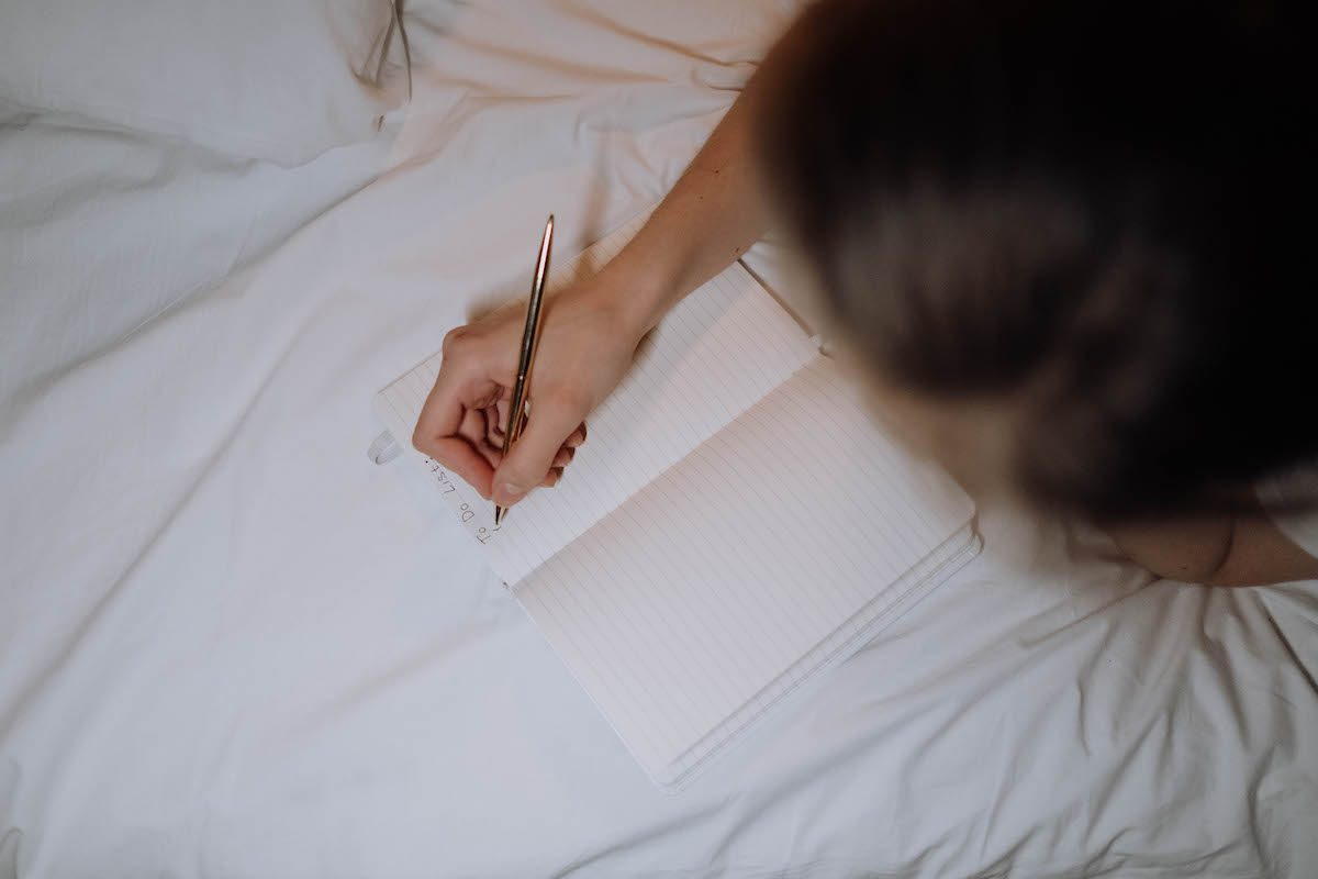 A person drawing up a to-do list on paper 