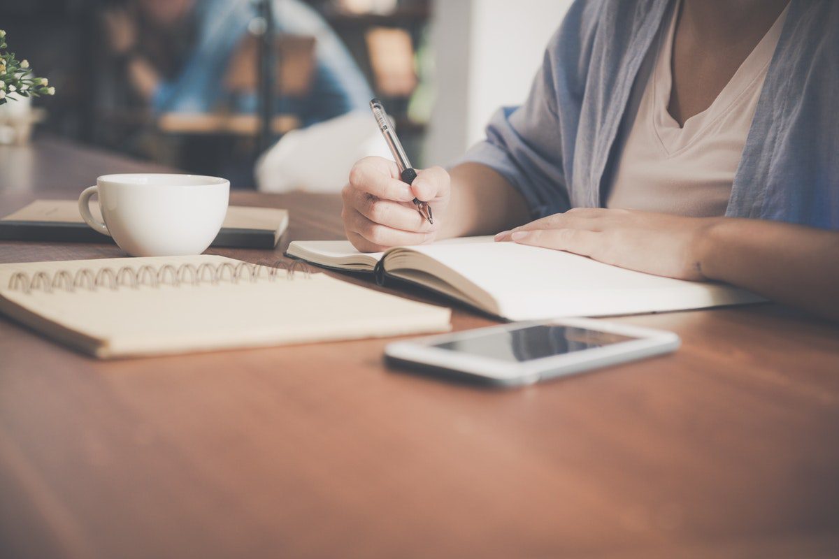 A woman writing in a notebook.