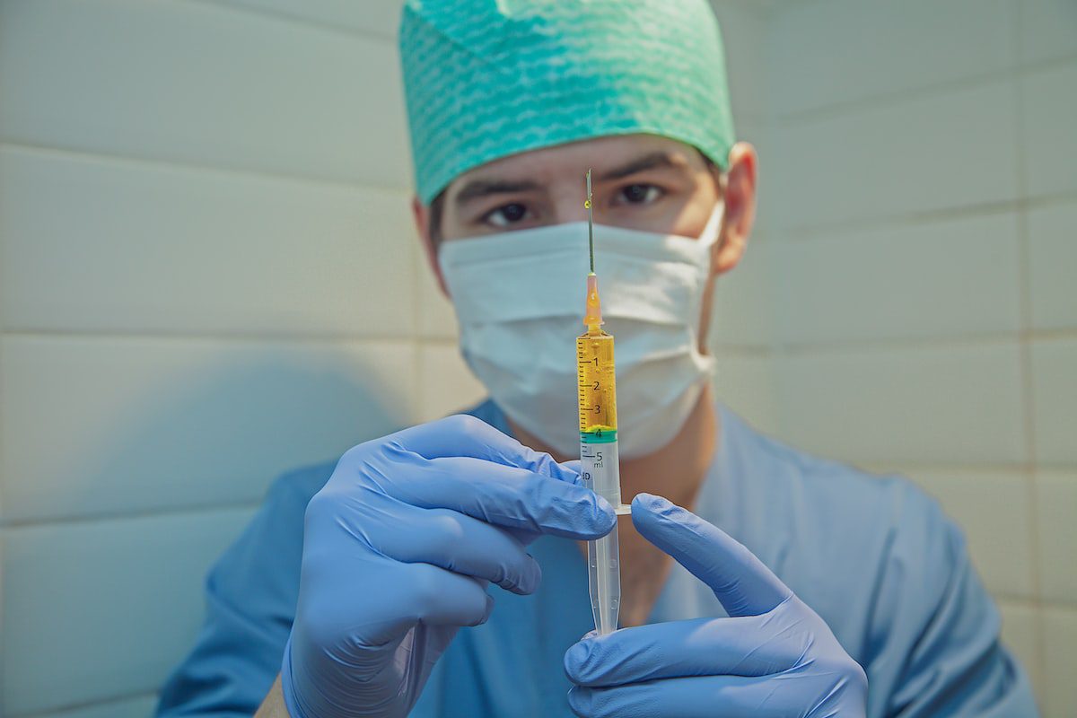 Nurse anesthetist squeezing a syringe