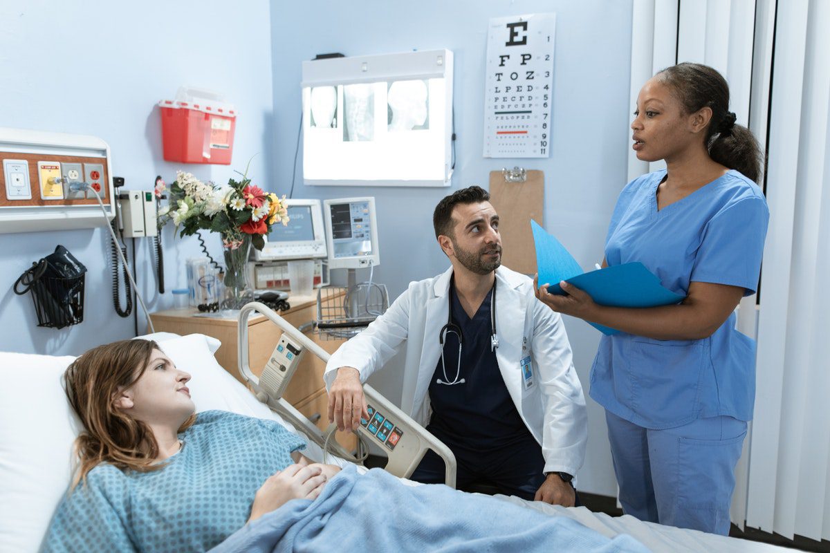 a physician assistant and a nurse attending a patient