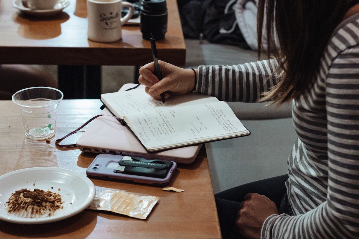 A person studying at a table in a restaurant. 