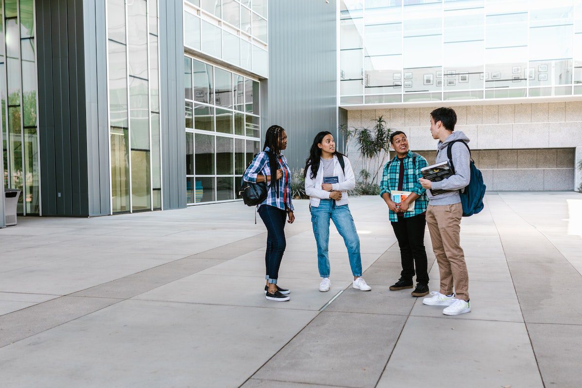 Two girls and two boys talking on the school grounds