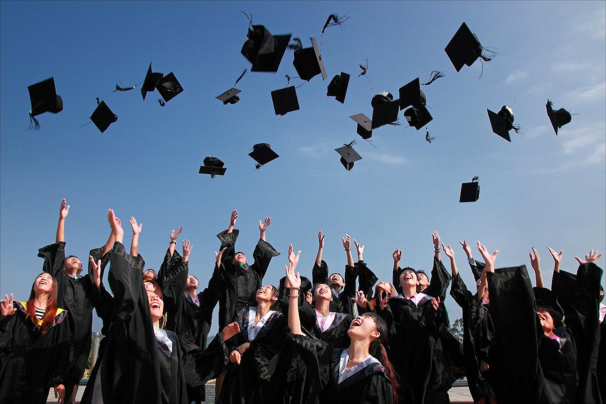 Graduates at Purdue University - main campus throwing their hats up towards the sky