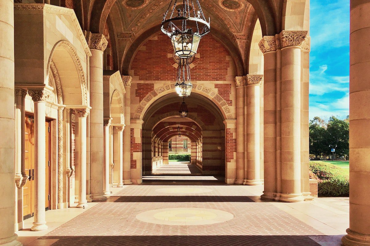 The exterior corridor of a brick and marble school building.