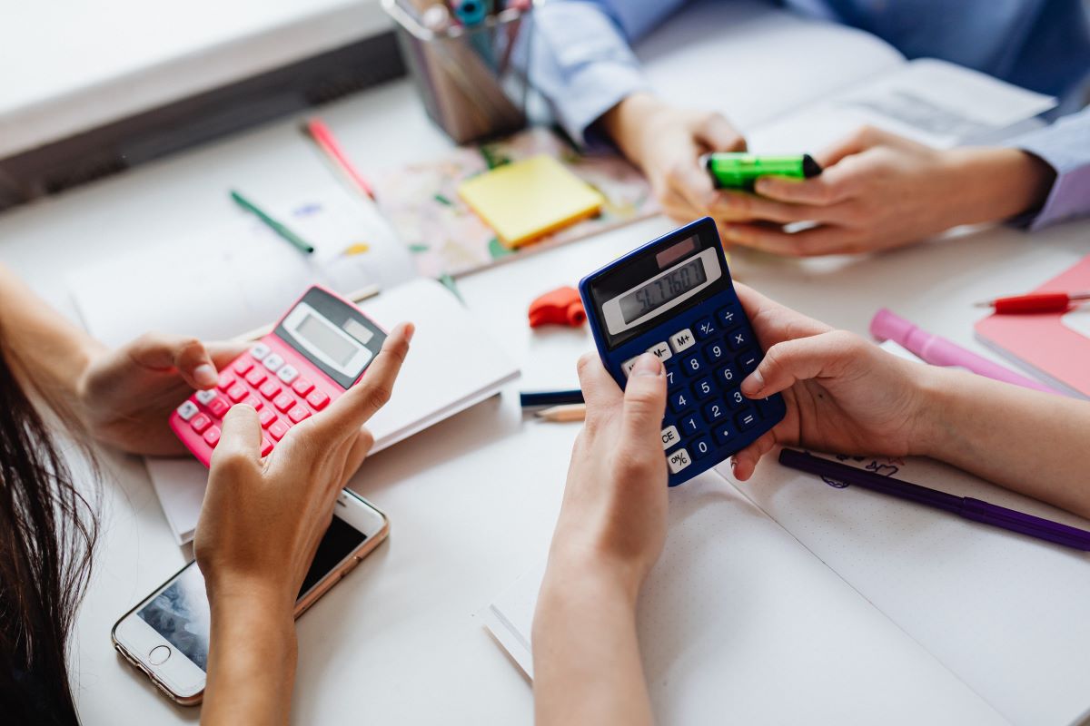 Three people solving mathematical problems using calculators