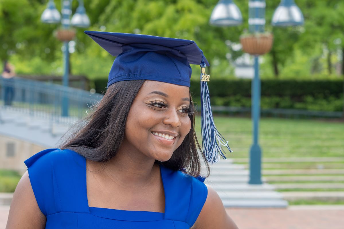 A student in a blue dress and graduation cap graduating from one of the specialty programs at the University of Michigan - Ann Arbor.