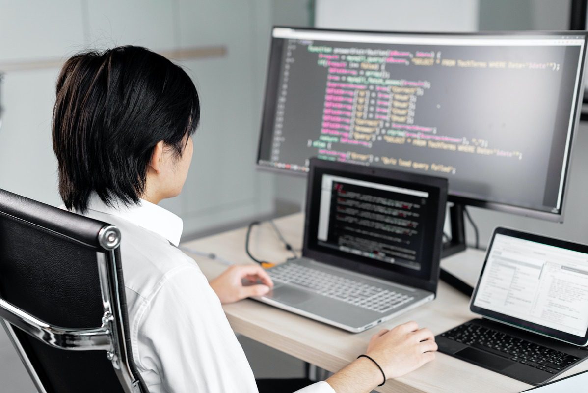 A student learning CSS on three computers.