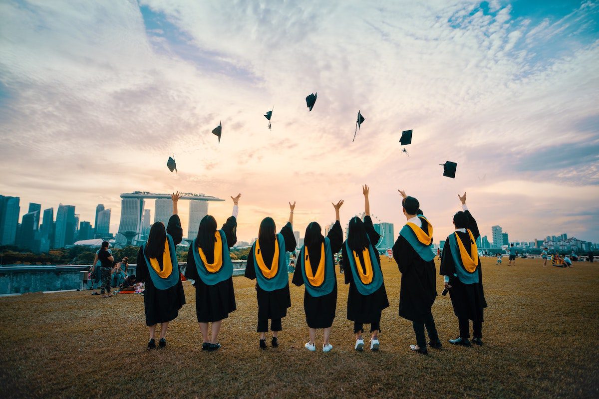 Students in graduation down throwing their hats in the air