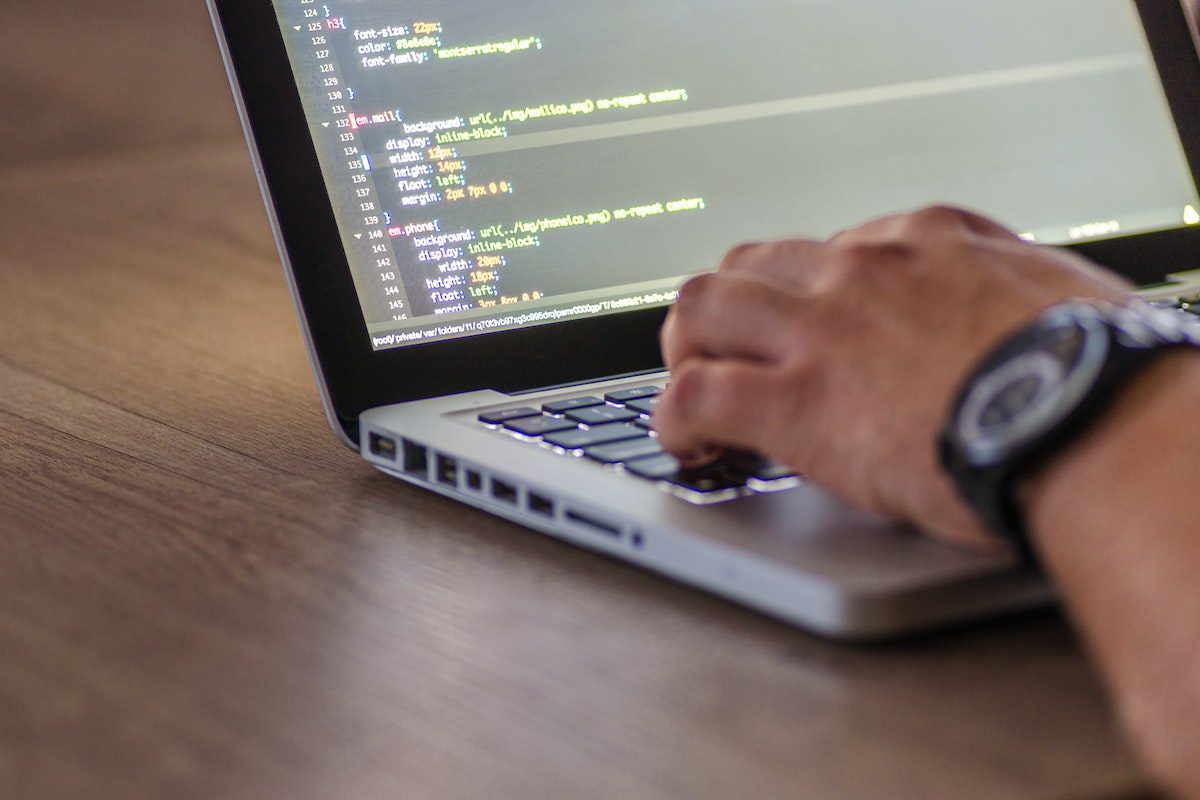 A man running long lines of code on a laptop