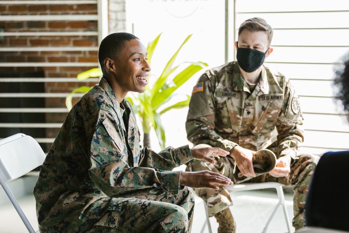 A male female and male veteran talking and smiling.
