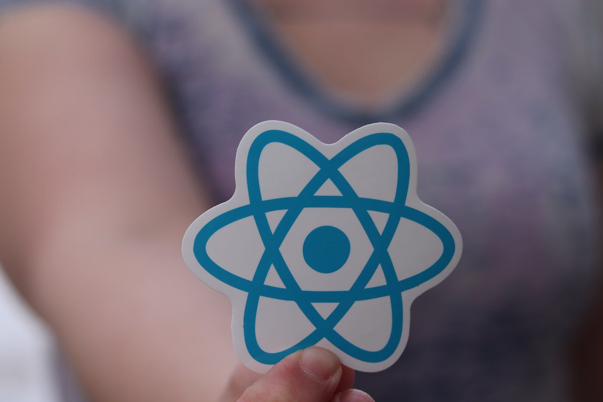 A hand holding React sticker.
