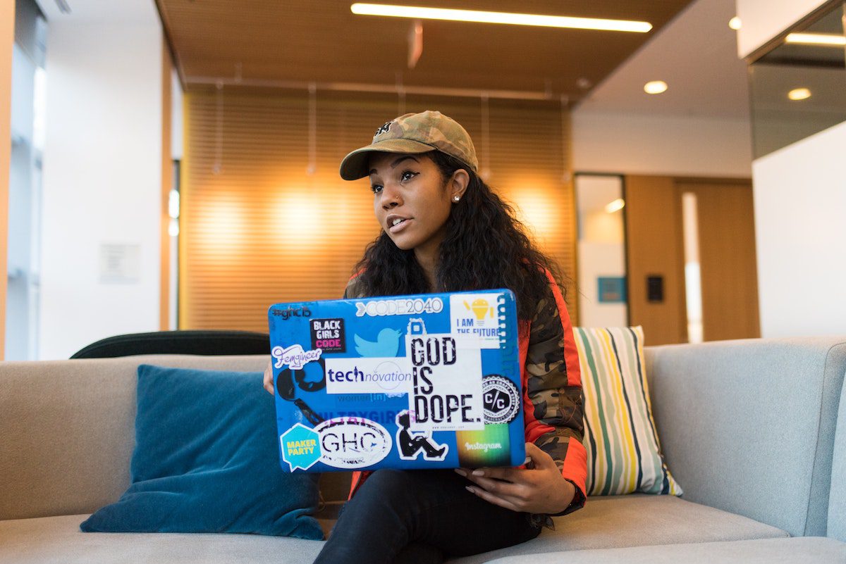 A female bootcamp student with a laptop on her lap