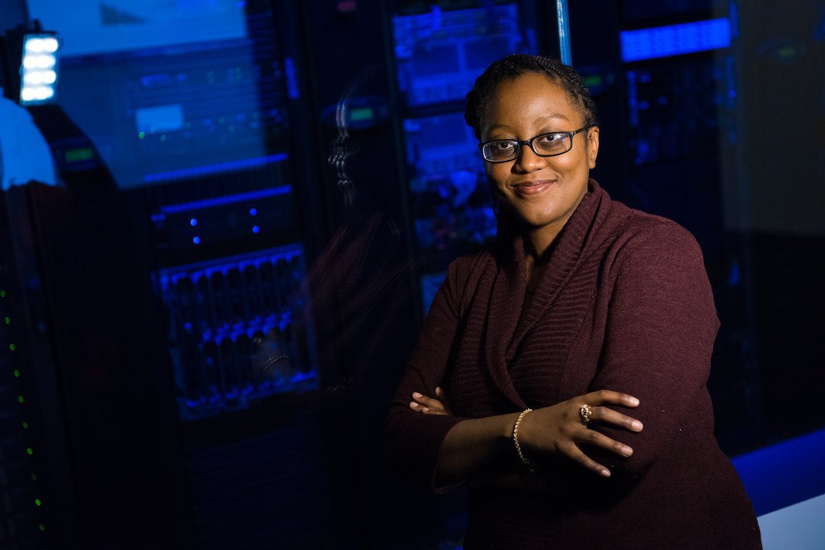 A female cloud software engineer crossing her arms and smiling.