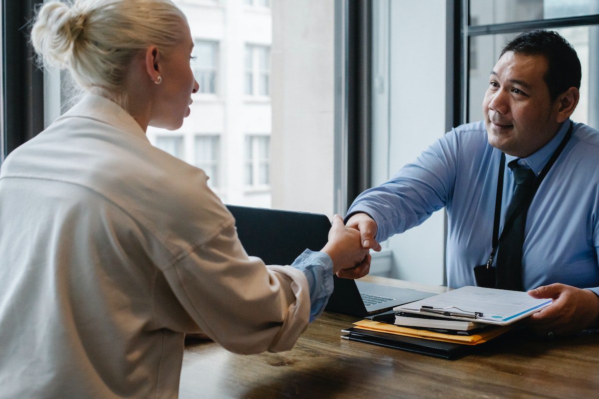 An employee shaking hands with her manager after selecting a program for tuition reimbursement.
