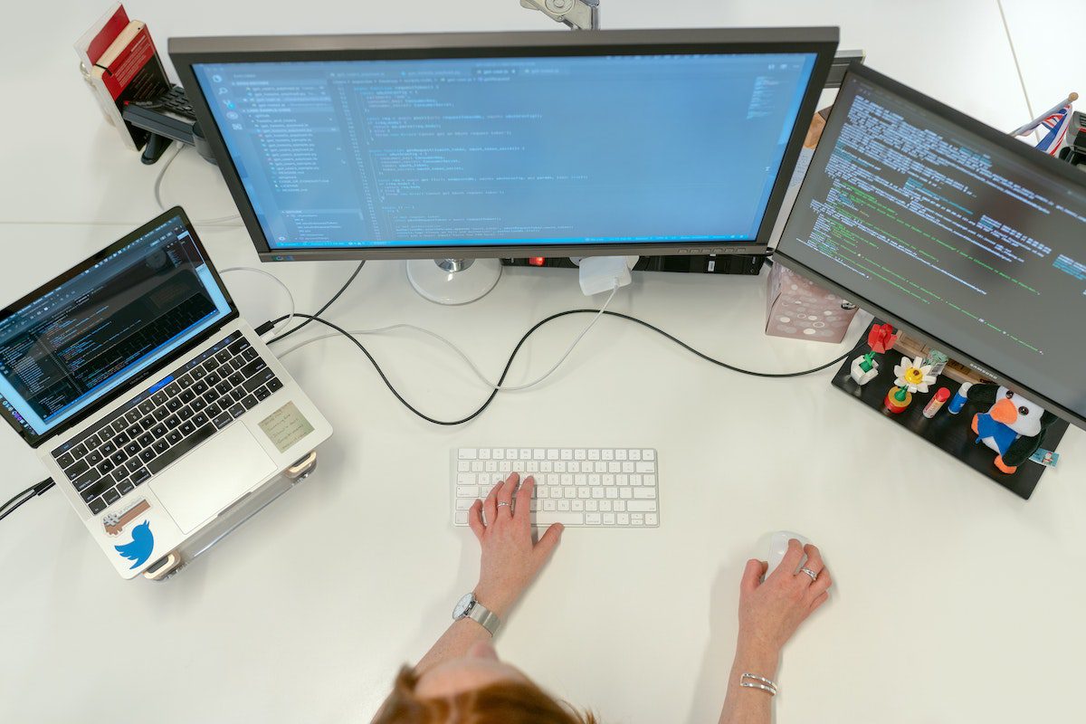 A software engineer working in front of several monitors.
